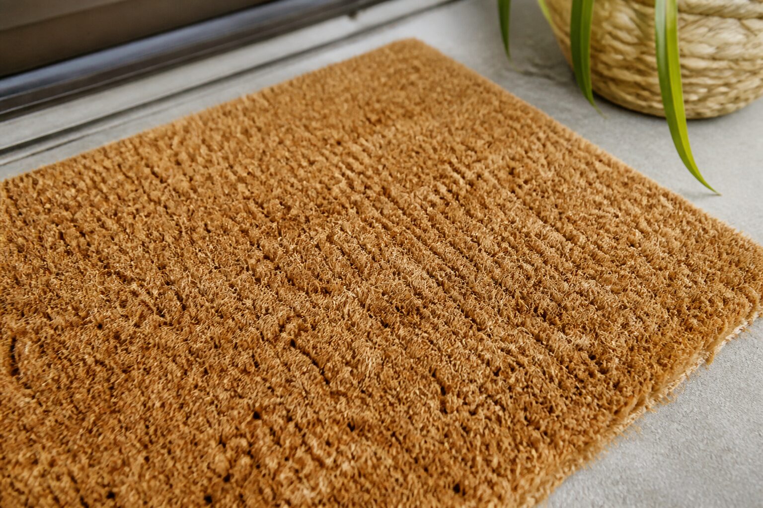 Gros plan sur la texture d'un paillasson coco personnalisé dans une entrée de maison