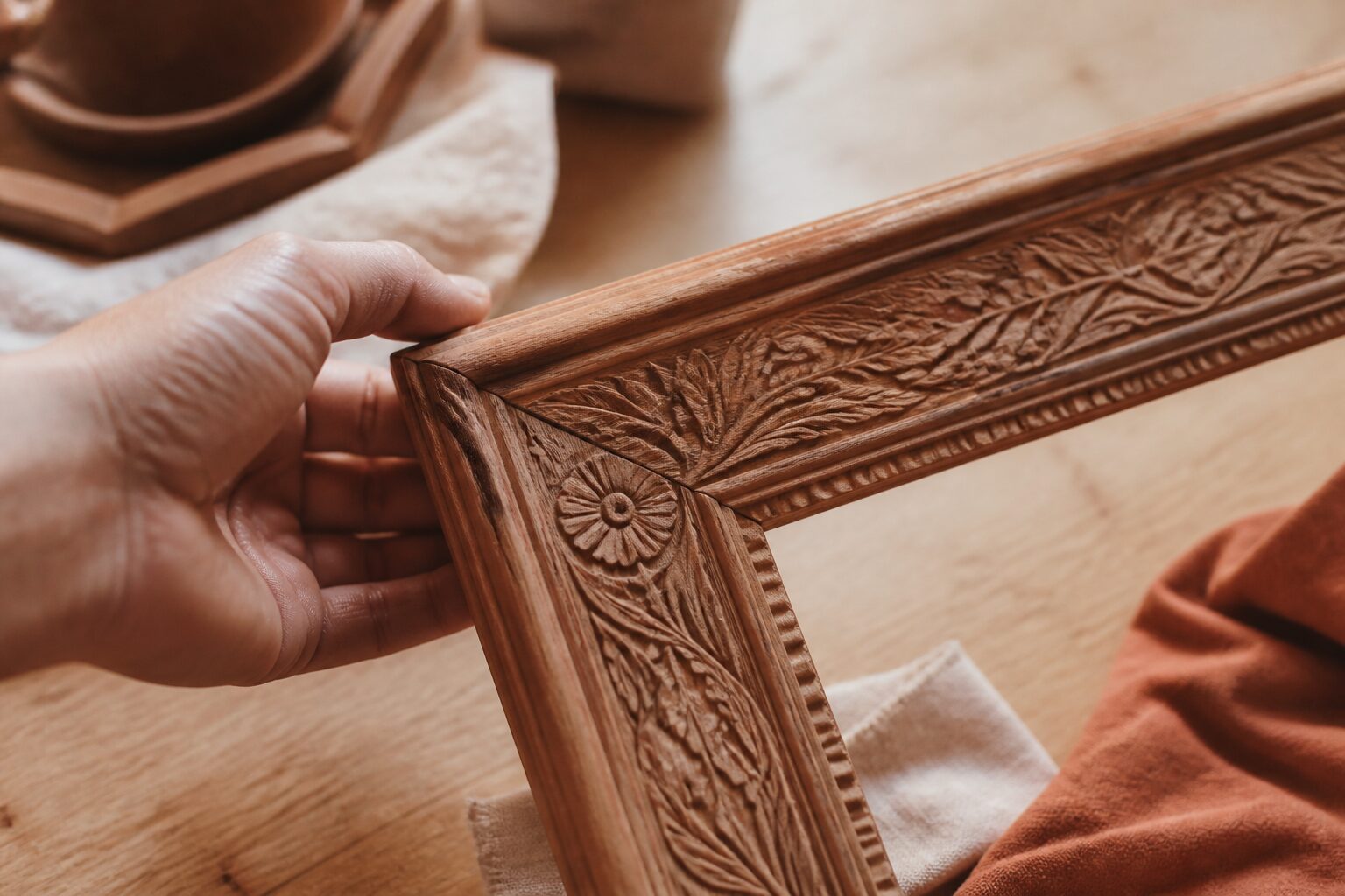Cadre bois gravé personnalisé artisanal tenu à la main, lumière naturelle chaude
