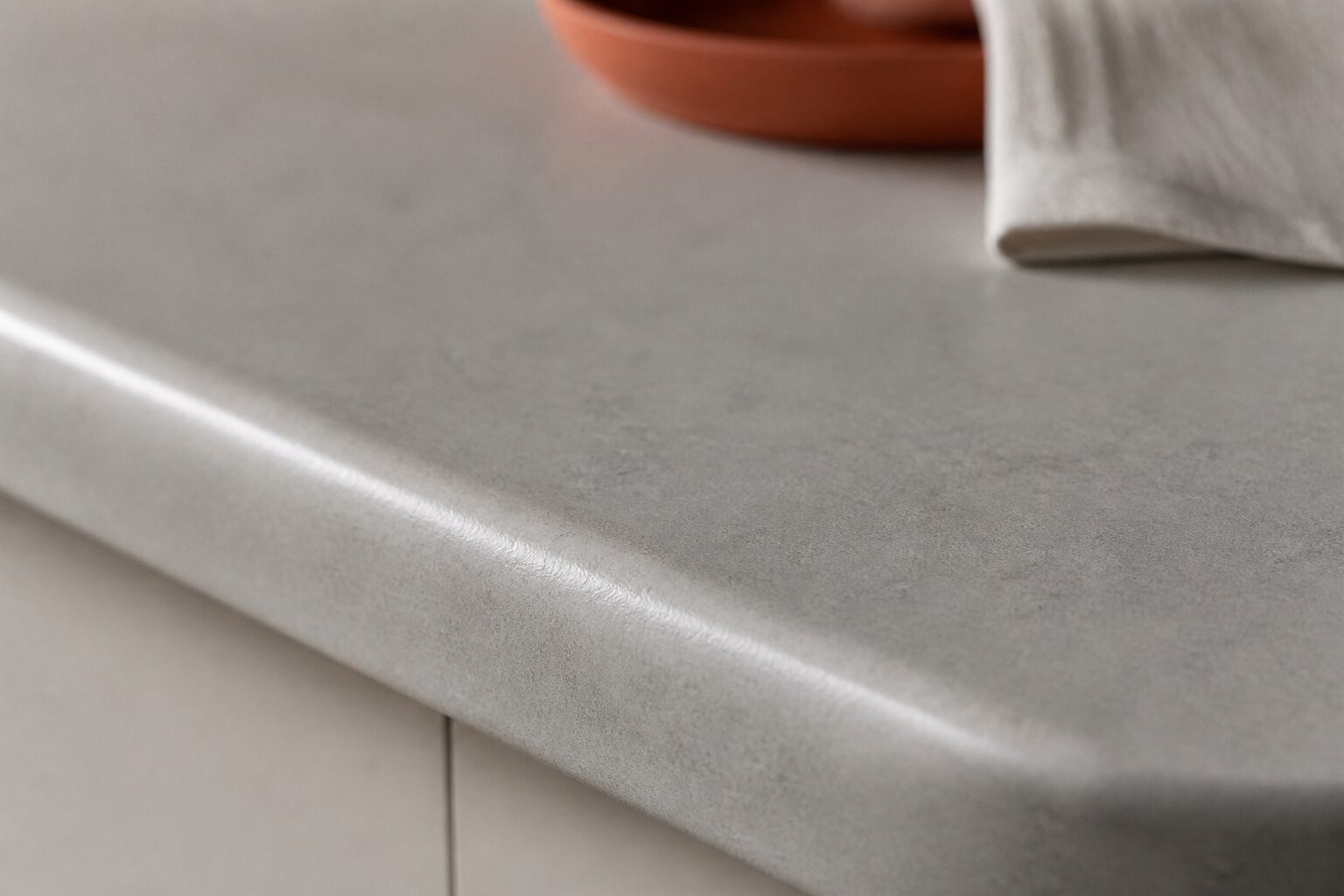 Gros plan sur la texture mate du corian plan de travail en gris perle avec bord arrondi thermoformé